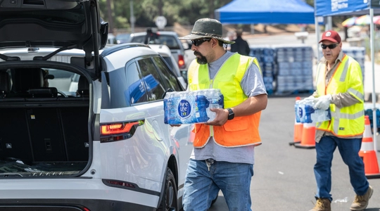 LADWP workers putting cases of water in residents cars