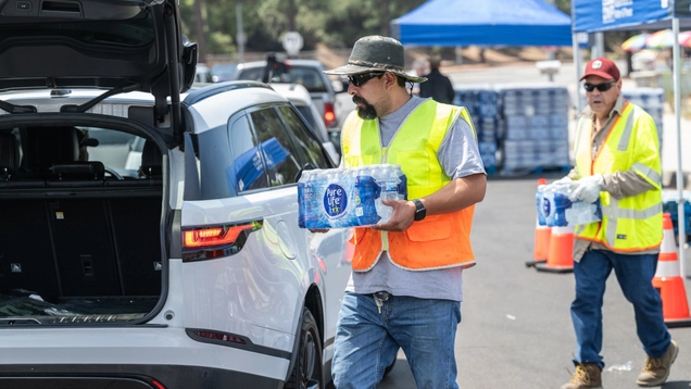 LADWP workers putting cases of water in residents cars